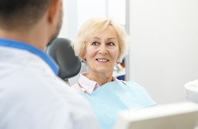 patient smiling while sitting in dental chair 