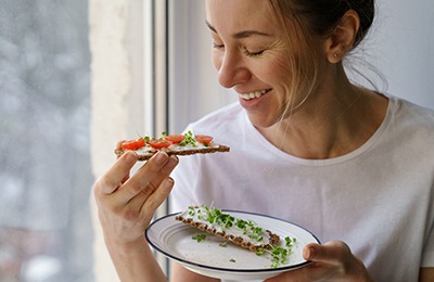 Woman smiling while eating healthy meal at home