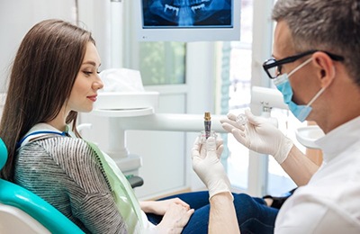 a dentist explaining the cost of dental implants