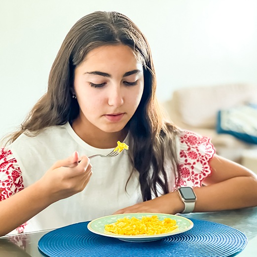 Young girl eating scrambled eggs 