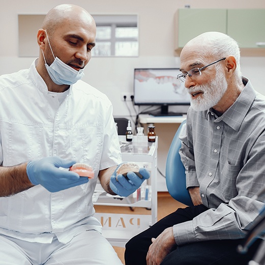 Dentist talking to patient about implant dentures 