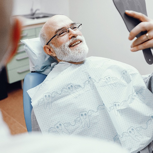 Male dental patient smiling into mirror