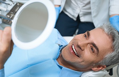 Man smiling at new dental implants 