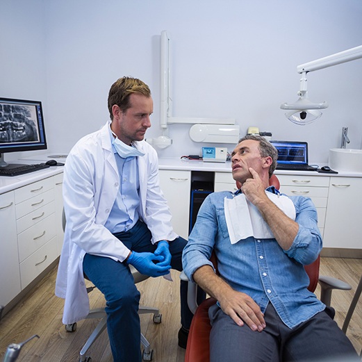 Male patient talking to dentist about dental implant 