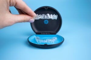 woman placing Invisalign tray in case 